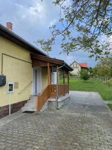a house with a wooden porch and a porch at Kiskatona Vendégház in Balatonkenese