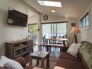 ein Wohnzimmer mit einem Sofa, einem TV und einem Tisch in der Unterkunft Handsome Dan's Vacation Cottage Rentals in Port Renfrew