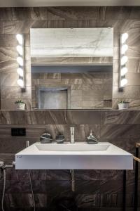 a bathroom with a white sink and a mirror at Manto Loft style apartment in Klaipėda