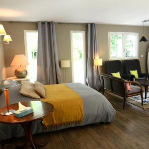 sypialnia z łóżkiem, stołem i krzesłami w obiekcie La Maison des Hérissons w mieście Bergerac