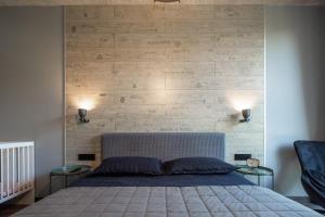 a bedroom with a bed with a wooden wall at Manto Loft style apartment in Klaipėda
