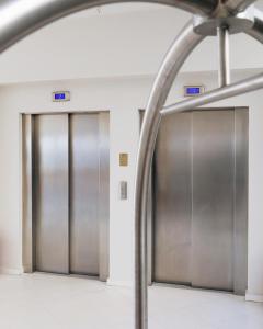 deux ascenseurs dans un bâtiment avec portes métalliques dans l'établissement Aegean Blue Beach Hotel, à Nea Kallikratia