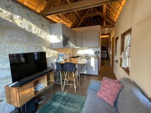 a living room with a couch and a kitchen at Le Manoir du Perroy in Saint-Wandrille-Rançon