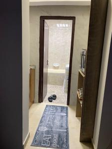 ein Badezimmer mit einer Tür, die sich zu einem Badezimmer mit einer Badewanne öffnet in der Unterkunft The theatre room in Abu Dhabi