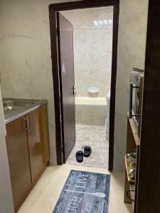 ein Bad mit einer Tür, die sich zu einem Bad mit einer Dusche öffnet in der Unterkunft The theatre room in Abu Dhabi