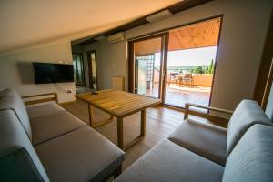 a living room with a couch and a wooden table at Apartments Sara in Portorož