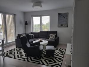 sala de estar con sofá y mesa en Apartament Baltica - Rezydencja Ustronie Morskie, en Ustronie Morskie