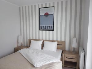 ウストロニエ・モルスキエにあるApartament Baltica - Rezydencja Ustronie Morskieのベッドルーム1室(ベッド1台付)が備わります。バスケットボールの写真を用意しています。