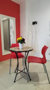 a table with two chairs and a vase with flowers on it at Massanè Casa Vacanza in Ginosa