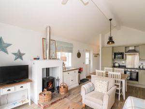 a living room with a fireplace and a kitchen at Sea Breeze in Filey +20 photos