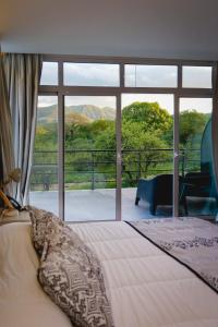 een slaapkamer met een bed en een groot raam bij La Posada Del Qenti in Villa Carlos Paz