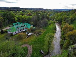eine Luftansicht eines großen Hauses mit grünem Dach in der Unterkunft Latarnia Wagabundy Bieszczady in Wola Michowa