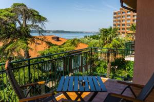 a blue bench on a balcony with a view of the water at Apartments Sara in Portorož