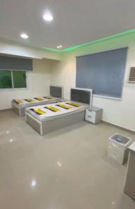 Zimmer mit 3 Betten und einer Leinwand in der Unterkunft شقق ريان المفروشه in Riad