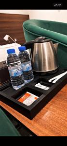 ein Tablett mit 2 Flaschen Wasser und einem Wasserkocher in der Unterkunft أضواء الشرق للشقق الفندقية Adwaa Al Sharq Hotel Apartments in Sīdī Ḩamzah