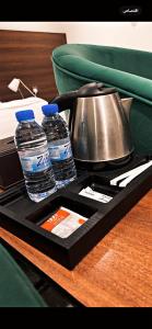 a tray with two bottles of water and a tea kettle at أضواء الشرق للشقق الفندقية Adwaa Al Sharq Hotel Apartments in Sīdī Ḩamzah