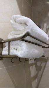 a pile of towels on a towel rack in a bathroom at أضواء الشرق للشقق الفندقية Adwaa Al Sharq Hotel Apartments in Sīdī Ḩamzah