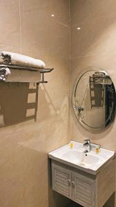 a bathroom with a sink and a mirror at أضواء الشرق للشقق الفندقية Adwaa Al Sharq Hotel Apartments in Sīdī Ḩamzah
