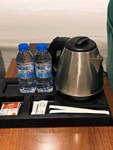 a tea kettle and two bottles of water on a tray at أضواء الشرق للشقق الفندقية Adwaa Al Sharq Hotel Apartments in Sīdī Ḩamzah