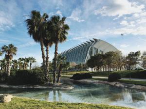a view of a building with palm trees and a pond at Mediterraneum Suite D in Valencia