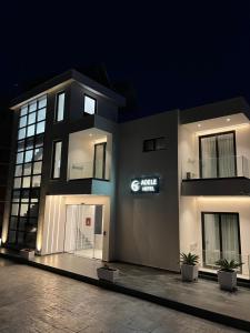 a building with a sign on the side of it at Adele Hotel Ksamil in Ksamil