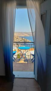 a view of a balcony with a table and chairs at Hotel Fiona Symi in Symi
