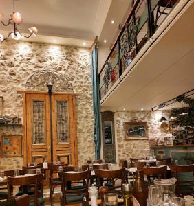 a restaurant with tables and chairs and a stone wall at Authentic Plaka Home in Athens