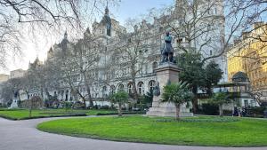 una estatua de una mujer frente a un edificio en Apartment London Eye Big Ben walk to China town en Londres