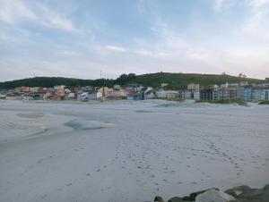 una spiaggia con impronte di piedi nella sabbia e nelle case di Apartamentos Turísticos O Pescador a Laxe