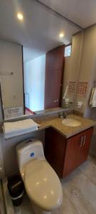 Un baño con un inodoro blanco y un lavabo. en Suites and Apartments Bogotá, en Bogotá