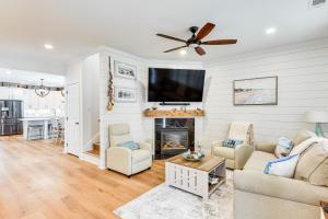 a living room with a fireplace and a flat screen tv at Charming Bluffton Home with Yard about 3 Mi to Beaches! in Bluffton