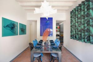 a dining room with a table and blue chairs at Villa Laura in Gardone Riviera