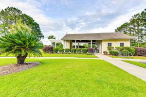 a house with a palm tree in front of a yard at Charming Bluffton Home with Yard about 3 Mi to Beaches! in Bluffton