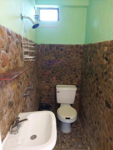 a bathroom with a toilet and a sink and a tub at Casa Cejota in Huautla de Jiménez