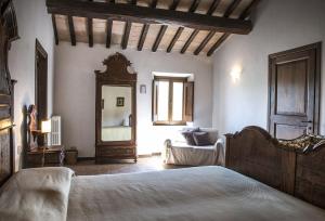 1 dormitorio con 1 cama grande y espejo en Agriturismo Piano Grande en Avigliano