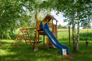 un parque infantil de madera con un tobogán y una escalera en Noclegi Bajama, en Siepraw