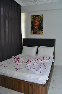 a bed with pink petals on it with a bunch of flowers at Side leon in Side