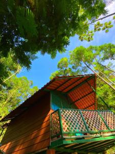 Las Arrieras Nature Reserve and Ecolodge في Horquetas: كابينة خشبية مع شرفة على الاشجار
