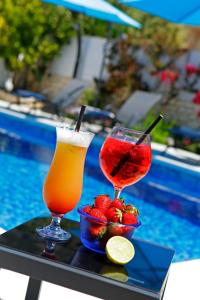 zwei Cocktails und Erdbeeren auf einem Tablett neben dem Pool in der Unterkunft Apartments Šemper - HEATED POOL in Bol