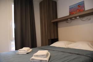 ein Schlafzimmer mit einem Bett mit Handtüchern darauf in der Unterkunft Mobilna kućica Nika in Šimuni