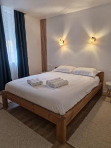 een slaapkamer met een groot bed en 2 handdoeken bij La Fontaine in Hauteville-Lompnes