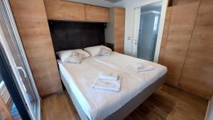 a bedroom with a bed with two towels on it at Mobile home 249 - Large Terrace & Private Jacuzzi in Selce