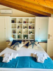 een slaapkamer met een groot wit bed met blauwe lakens bij Sweet Dream House in Carloforte