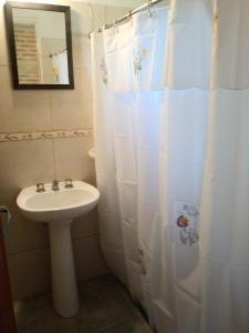baño con lavabo y cortina de ducha en Bungalows Tiempo Libre en Colón