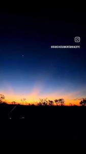 una puesta de sol en un campo con el cielo en Rancho da Montanha Cipó, en Serra do Cipo