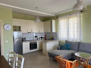 een keuken en een woonkamer met een bank en een tafel bij Vila Aleks in Vuno