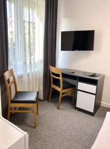 比亞韋斯托克的住宿－DOBA RENT Wysockiego 104，客房设有一张桌子、两把椅子和一台电视。