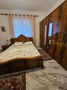 una camera con letto in legno e finestra di Aira Villa a Përmet