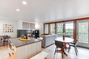 a kitchen and living room with a table and chairs at Chic Bend Condo with Fireplace and Forest Views! in Bend