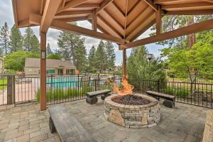 a patio with a fire pit and benches and a fence at Chic Bend Condo with Fireplace and Forest Views! in Bend